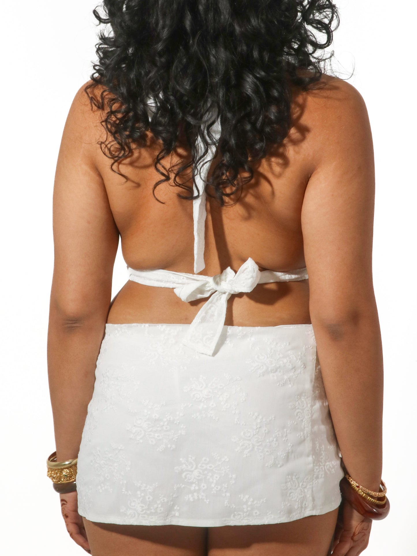 Model wearing a white scoop neck top from Yasmin The Label featuring adjustable ties at the top and back; clean minimalist design shown on model who is a size 10-12 and wears M/L.